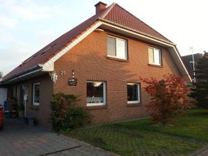 a brown brick house with a gambrel roof at Ferienwohnnung Kathrin in Wremen