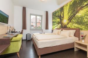 a bedroom with a bed and a desk and a window at Radlhotel Wassertrüdingen in Wassertrüdingen