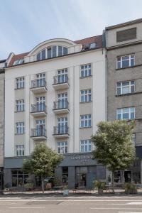 a large white building with a balcony at Hotel Gdynia Boutique in Gdynia