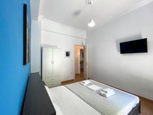 1 dormitorio con 1 cama y TV en la pared en SOHO Charming 55sqm apt in Athens, en Atenas
