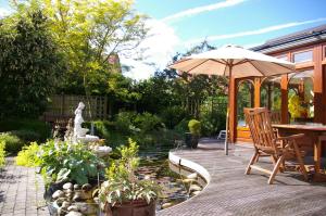a patio with an umbrella and a table and chairs at B&B VILLA MONIQUE in Koksijde