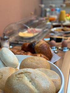 una mesa con platos de bagels y pan. en B&B VILLA MONIQUE, en Koksijde