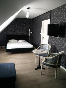 Schlafzimmer mit einem Bett, einem Tisch und Stühlen in der Unterkunft B&B VILLA MONIQUE in Koksijde