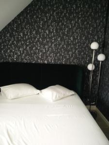 a bedroom with a bed with two pillows and two lamps at B&B VILLA MONIQUE in Koksijde +1 photo