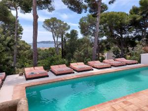 uma piscina com um monte de espreguiçadeiras ao lado em Villa Dora (Only adults) em Xàbia