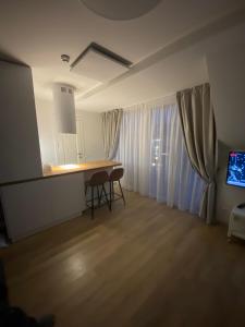 a living room with a table and a television at Apartamentai Kunigiškėse in Palanga