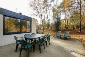 a patio with a table and chairs next to a building at Center Parcs Erperheide in Peer