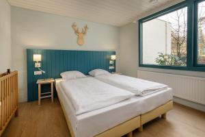 佩尔Center Parcs Erperheide的一间卧室设有一张大床和一个窗户。