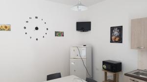 a kitchen with a refrigerator and a tv on the wall at Case vacanza Controvento in Palermo