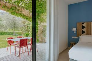 a bedroom with a bed and a table and chairs at Can Alemany in Santa Margarita de Mombúy