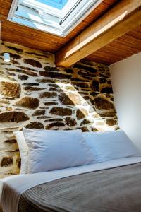 łóżko w pokoju z kamienną ścianą w obiekcie Traditional Apartments Elafos w Elafonisi