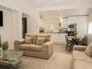 a living room with two couches and a kitchen at Mere Brook Lodge in Windermere