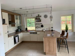 a kitchen with white cabinets and a wooden table at Neuhaus Deichperle in Krummhörn