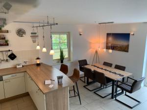 a kitchen and dining room with a table and chairs at Neuhaus Deichperle in Krummhörn