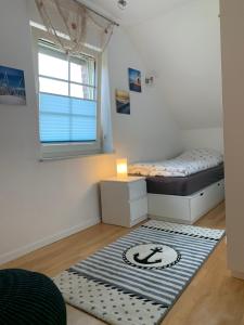 a small bedroom with a bed and a rug at Neuhaus Deichperle in Krummhörn