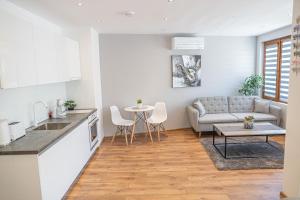 uma cozinha e sala de estar com um sofá e uma mesa em Shushi's Central Studio Apartment em Plovdiv