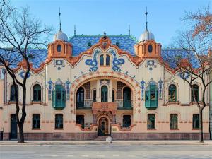 a large building with green windows and a blue roof at MB Apartment in Subotica