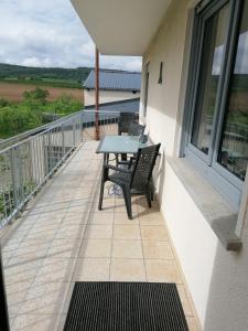 un patio con tavolo e sedie su un balcone di Ferienwohnungen Rosenhof a Karlstadt Altre 9 foto