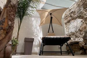 a chair with an umbrella in a room at Tufoletto Apartment in Palermo