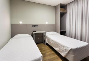 a hospital room with two beds and a desk at Tropikalya Gold Hotel in Balneário Camboriú