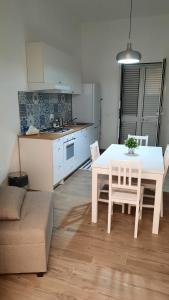 uma cozinha e sala de jantar com uma mesa branca e cadeiras em A casuzza em Marzamemi