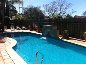 a swimming pool in a backyard with a wooden fence at Marion Motel and Apartments in Adelaide