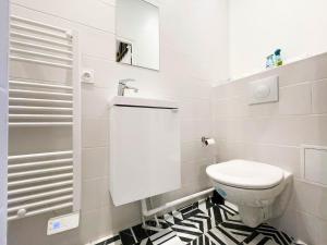 a bathroom with a toilet and a black and white tile floor at LA GRACIEUSE - MILORA INN - Central Paris in Paris