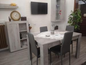 a dining room table with chairs and a clock on a wall at A casa di Raffaella e Antonio in Surbo