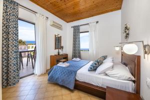 a bedroom with a bed with a view of the ocean at Villa Kapnisi in Vasilikos