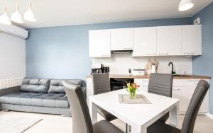 a kitchen and living room with a white table and chairs at Apartament Future in Kołobrzeg