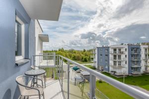 a balcony with chairs and a view of a building at Apartament Future in Kołobrzeg