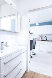a kitchen with white cabinets and a dining room at Apartament Future in Kołobrzeg