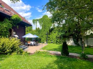 eine Terrasse mit einem Tisch und einem Sonnenschirm im Hof in der Unterkunft Art Pension dans le Parc in Banská Bystrica
