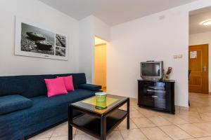 a living room with a blue couch and a tv at Adrijana in Krk