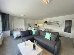 a living room with a couch and a bed at Residentie Duinenzucht - Appartement Laure I Studio Lynne in Bredene