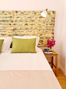 a bedroom with a white bed with a brick wall at Casa Lara by HnM in Tavira