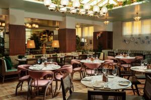 a restaurant with tables and chairs and a bar at The Hoxton, Rome in Rome