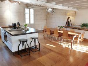 a kitchen and dining room with a table and chairs at QUAI 3 loft moderne et lumineux les pieds dans l'eau in Jarnac