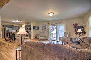 a living room with a couch and a kitchen at Lake Champlain Home with Decks, Kayaks and Fire Pit! in Saint Albans Bay