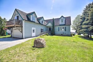 Saint Albans Bay的住宿－Lake Champlain Home with Decks, Kayaks and Fire Pit!，一座大蓝色房子,院子里有岩石
