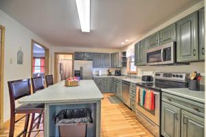 a large kitchen with green cabinets and a counter top at Lake Champlain Home with Decks, Kayaks and Fire Pit! in Saint Albans Bay