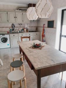 a kitchen with a large wooden table and chairs at Casa do gato branco in Furadouro