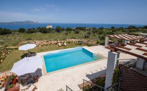 a villa with a pool and a view of the ocean at Villa PhenΩmena Apartments in Kókkinon Khoríon