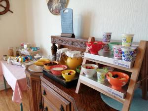 a room with a table with many different bowls and cups at Craig-y-Mor in Criccieth