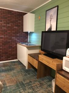 Una sala de estar con un televisor grande y una cocina. en Alpine motel, en Rocky Mountain House 81 fotos más