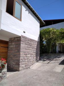 una casa blanca con una pared de ladrillo y una puerta en Apartments Simovic, en Tivat