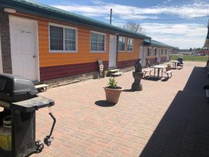 a building with a brick patio with a house at Alpine motel in Rocky Mountain House