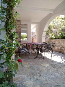 een patio met een tafel en stoelen op een stenen vloer bij Apartments Simovic in Tivat