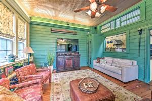 a living room with green walls and a ceiling fan at The Lilly House Historic Glen Rose Home with Porch! in Glen Rose