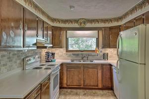 a kitchen with wooden cabinets and a white refrigerator at Pet-Friendly Finger Lakes Home Near Wineries! in Ovid